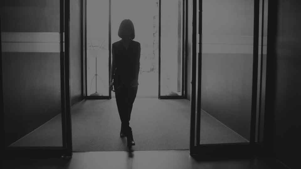 IGI Board Member & Executive Vetting woman walks through main door of building black and white
