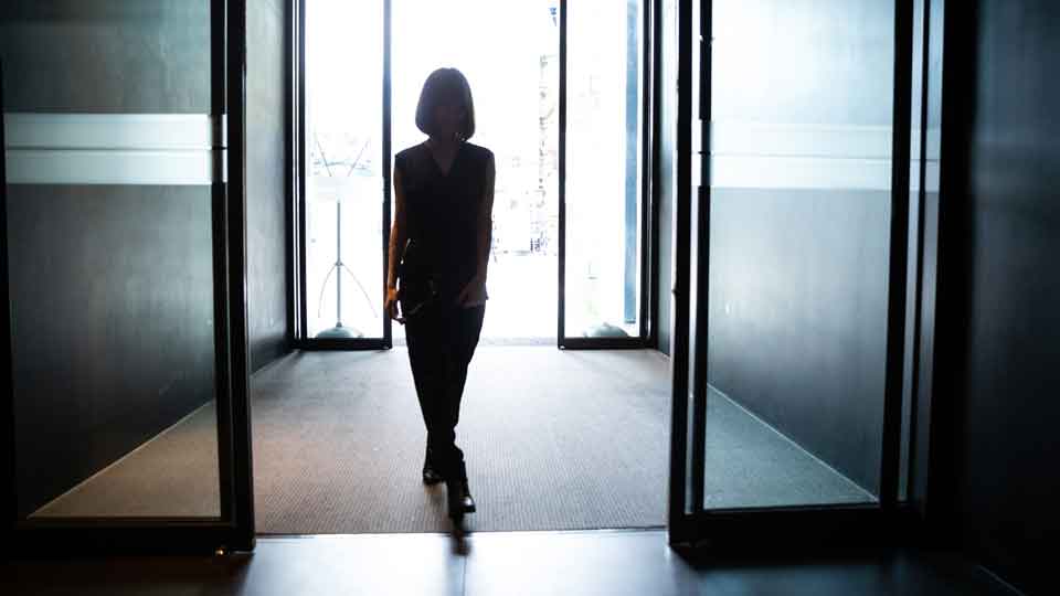IGI Board Member & Executive Vetting woman walks through main door of building 